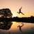 silhouette photo of man jumping on body of water during golden hour